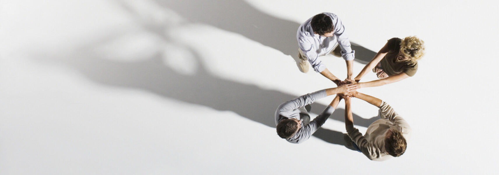 Four People Placing Hands Over Each Other’s, Overhead View